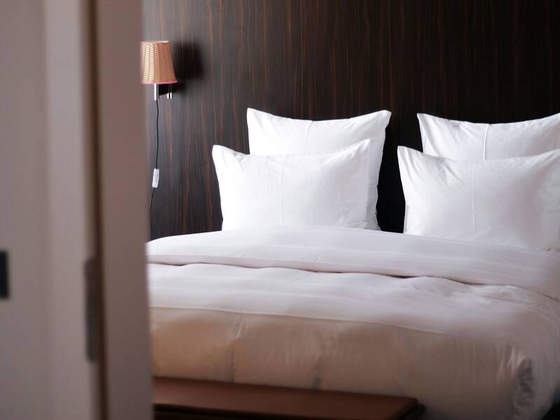 Einladendes Hotelbett mit Kissen und Bettdecke.