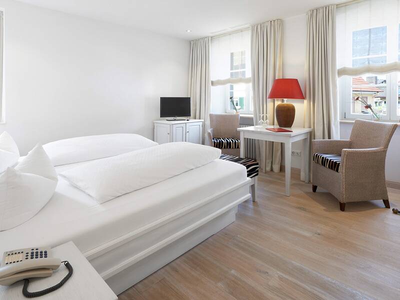 Die Markgräfler Stube mit Doppelbett und kleiner Sitzecke.