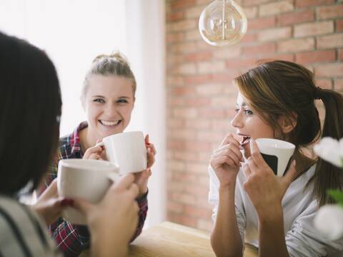 Frauen die sich bei einem Kaffee miteinander unterhalten.